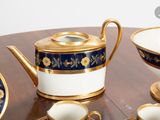 a table with a tea pot, cups and saucers on it