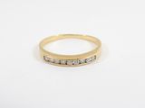 a yellow gold ring with three diamonds on a white background