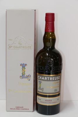 Des bouteilles de vin sont posées à côté d'une boîte sur une surface blanche.
