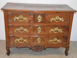 a wooden chest of drawers with gold decorations on it