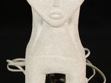 a white ceramic sculpture of a person with a face on it