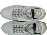 pair of white sneakers with silver laces on a white background
