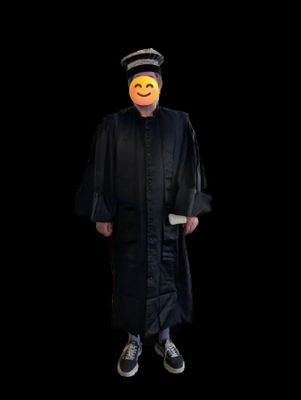 un homme vêtu d'une robe noire et d'un chapeau, avec un smiley sur le visage