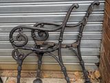 un banc en métal situé devant un bâtiment