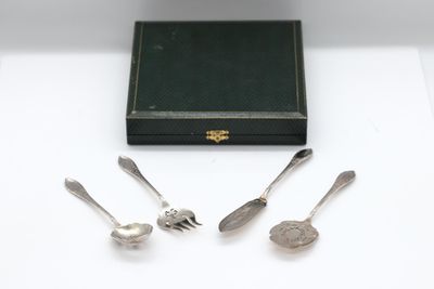 four silver spoons and a box on a table