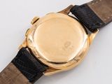 a close up of a watch on a white surface