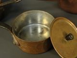 pots and pans sitting on a table with lids open