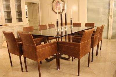 une table en verre entourée de chaises, au milieu d'une pièce
