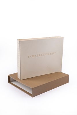 a white book sitting on top of a wooden shelf next to a box