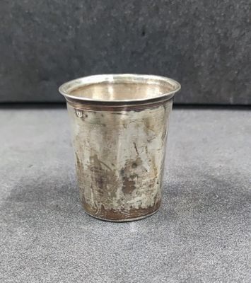 a close up of a silver cup sitting on a table