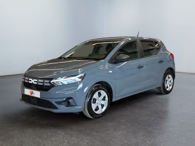 Une voiture bleue est garée dans une pièce aux murs blancs