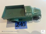 un petit camion vert en plastique posé sur une table