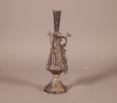 un vase en argent posé sur un socle en métal