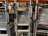 several metal ladders are stacked on top of each other in a warehouse