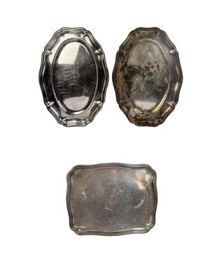 deux plateaux en argent et une assiette en argent sur fond blanc