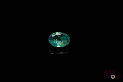 a close up of a green sapphire stone on a black surface