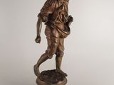 bronze figurine of a man holding a baseball bat and ball