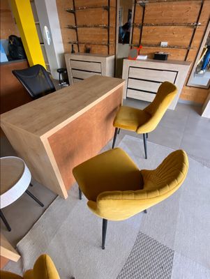 two yellow chairs sitting in front of a desk in a room