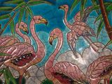 painting of a group of pink flamingos on a blue and green plate
