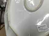 a close up of a white vase with a tag on it