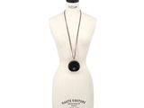the mannequin is holding a black necklace on a white mannequin