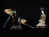 trois figurines d'oiseaux sur fond noir, avec un fond noir