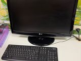 a computer monitor and keyboard sitting on a desk
