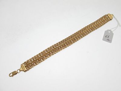 Gros plan sur un bracelet en or portant une étiquette