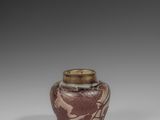a brown and white vase sitting on top of a table