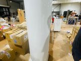 a man standing next to a tall white object in a warehouse