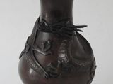 a brown vase with a dragon on it on a table