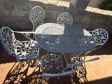 une table et des chaises blanches installées dehors, sur une terrasse
