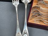 a lot of silver spoons and forks in a box