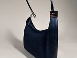 a black leather handbag with a metal handle on a white surface