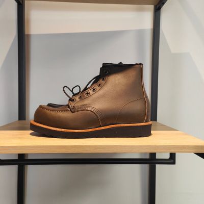 des bottes marron posées sur une étagère dans une pièce aux murs blancs