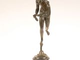 statue en bronze d'une femme tenant un oiseau sur un piédestal