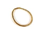 a close up of a gold bracelet on a white surface