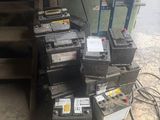 a pile of batteries sitting on the floor next to a pile of boxes