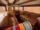brightly colored couches in the back of a bus with a brick wall in the background