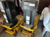 deux poubelles noires posées sur un chariot jaune