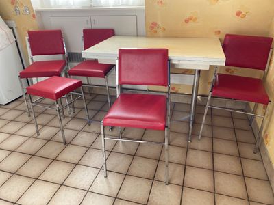 four red chairs and a white table in a kitchen