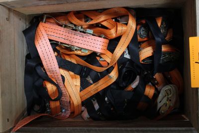 une caisse en bois remplie d'une multitude de ceintures orange et noires