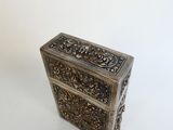 an old silver box sitting on top of a white surface