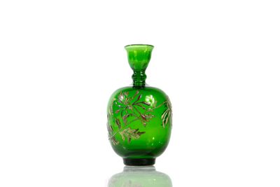 a green glass bottle with a gold design on it