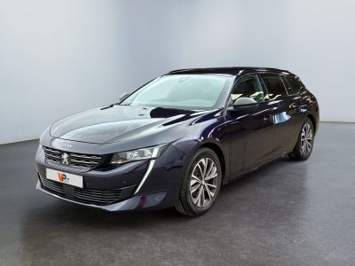 La voiture bleue est garée dans une pièce blanche au sol noir.