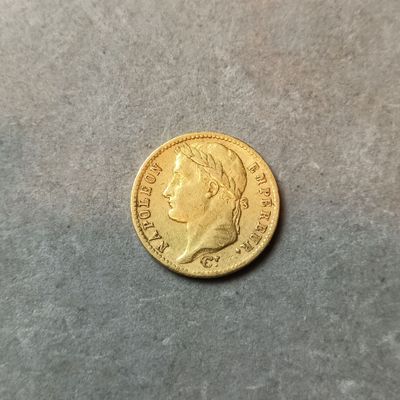 gros plan d'une pièce d'or sur une surface grise