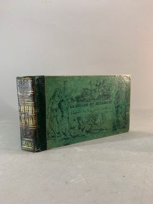 un vieux livre posé sur une table blanche, à côté d'une lampe