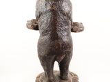 statue of a bear standing on a rock on a white background