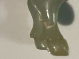 a green bear shaped object on a white surface