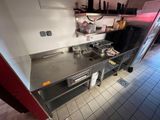 une cuisine équipée d'une cuisinière, d'un four, d'un évier et de placards